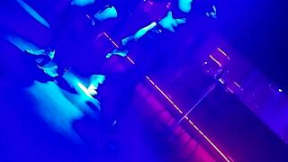 Go-go dancer invites brunette to dance and lifts dress