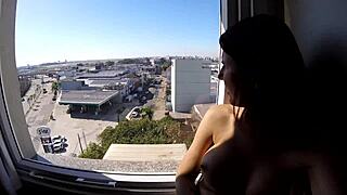 Sarada stands naked in the hotel window overlooking the airport