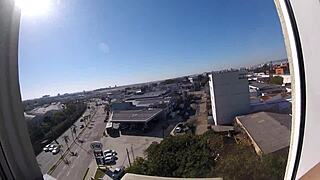 Sarada stands naked in the hotel window overlooking the airport