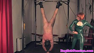 Femdom tramples her slave after a whipping session in latex bondage