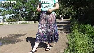 Hairy mature struts outdoors in a see-through dress
