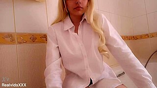 a blonde girl gropes her natural tits and shaved pussy relaxing in the bathroom before bath.