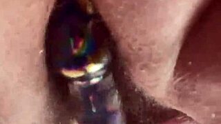 Curvy woman masturbates hairy pussy with glass dildo close up