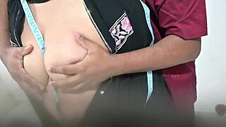 Tailor using hijab lady while taking measurement of blouse