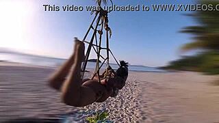 The shibarist ties the brunette in the coconut tree