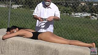 Dr. Grey gives an oiled massage to his Asian patient outdoors