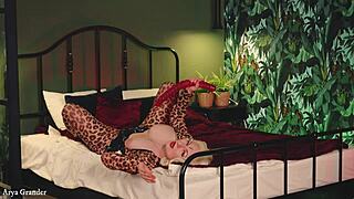 mature blonde poses in tight spandex catsuit on bed