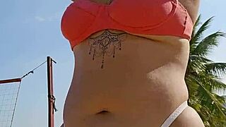 african exhibitionist flashes teasing males while recording beach video provocatively