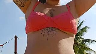 african exhibitionist flashes teasing males while recording beach video provocatively