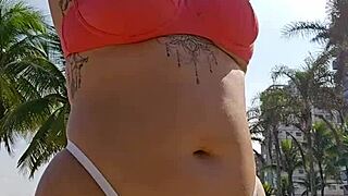 african exhibitionist flashes teasing males while recording beach video provocatively