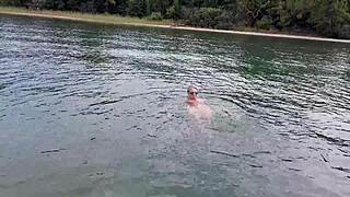 mature woman swims naked outdoors