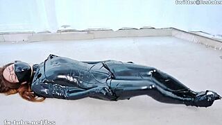 Asiatisk latex catsuit dame bundet i interessant sleeppack oppsett